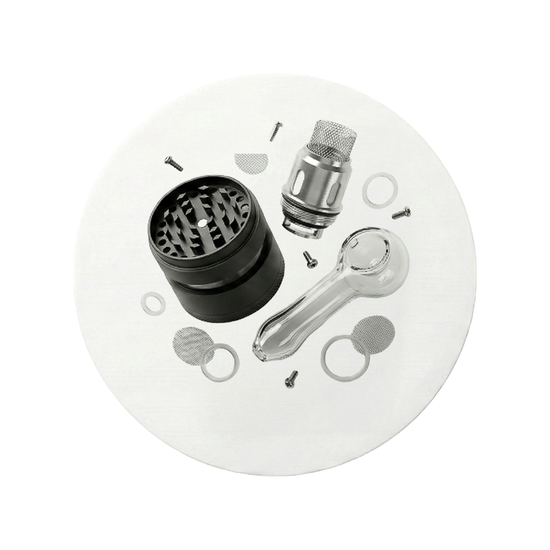 Aranjament accesorii fumat cu grinder negru și pipă din sticlă pe suport rotund alb.