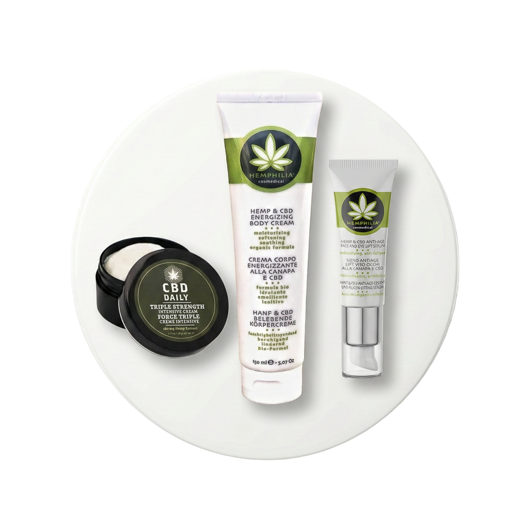 Set cosmetice CBD Daily cu balsam, cremă și loțiune pe disc alb de prezentare.