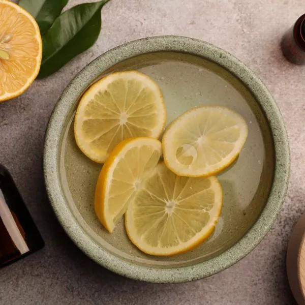 History 12 Felii de lămâie proaspătă într-un bol cu apă, reprezentând terpenele și aromele naturale.