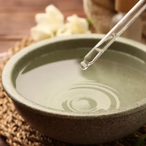 History 8 Detaliu macro cu o picătură de extract pur căzând dintr-o pipetă într-un bol.