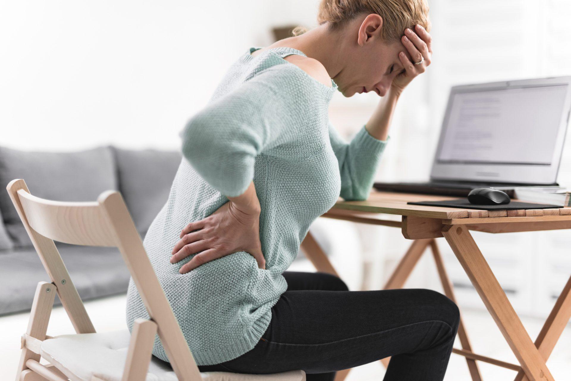 CBD și Sciatica: Cum să calmezi durerea „fulgerătoare” de pe picior? 1 Femeie stresată la birou ținându-se de cap, efectele oboselii și sindromului de burnout. CBD pentru sciatica